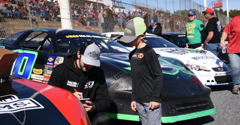 NASCAR - Racing Driver Signing Autograph to Boy near NASCAR Cars