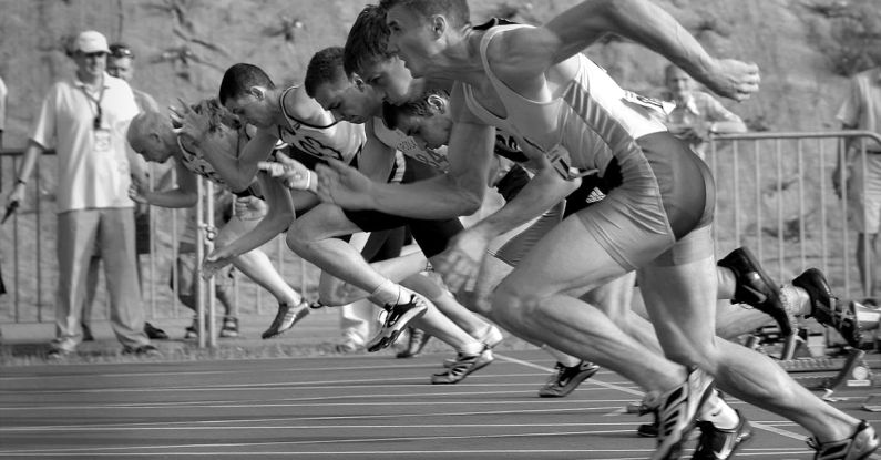 Race - Athletes Running on Track and Field Oval in Grayscale Photography