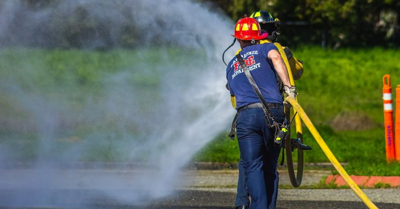 Emergencies - A firefighter spraying water on a road